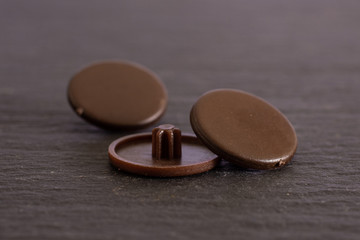 Group of three whole brown plast plugs work item on grey stone