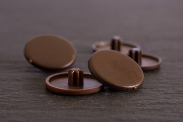 Group of five whole brown plast caplugs work item on grey stone