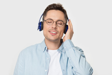Relaxed man in glasses wear headphones enjoying favorite music