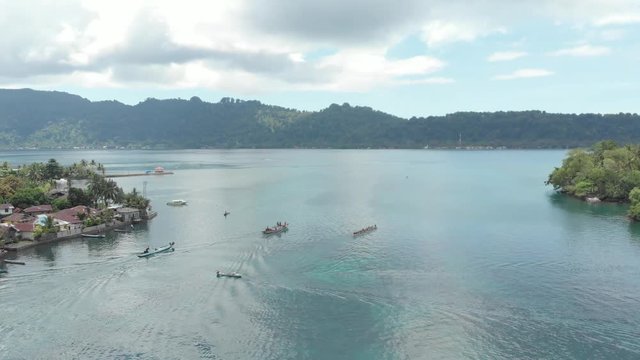 Aerial: kora-kora traditional canoe annual race in Bandaneira in the beautiful sea of the Banda Islands, Maluku, Indonesia. Native cinelike D-log color profile