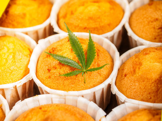 Delicious homemade baked cinnamon muffins with marijuana leaf garnish. Cookies with cannabis and buds. Treatment of medical marijuana for use in food.