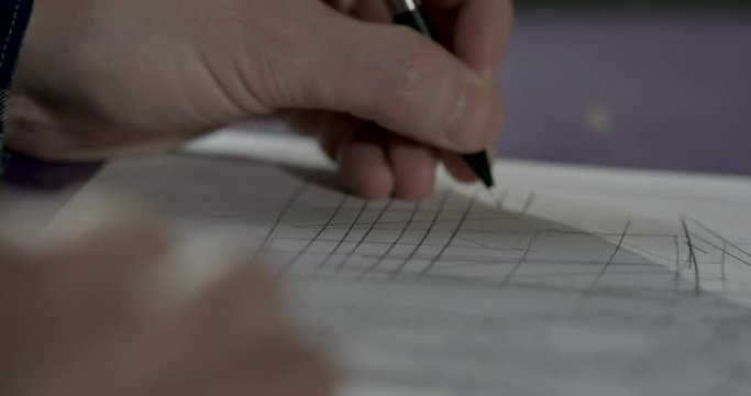 Sketch artist drawing lines on paper with sketch pencil.