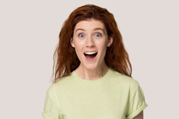 Surprised red-haired girl amazed by shocking news