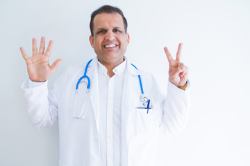 Middle age doctor man wearing stethoscope and medical coat over white background showing and pointing up with fingers number seven while smiling confident and happy.