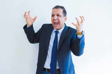 Middle age business man celebrating and screaming happy for succesful win