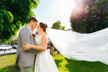 the newlyweds closed their eyes and hug. trees and green grass