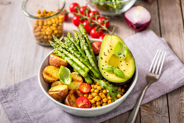 Buddha bowl with green asparagus and  baked potatoes, spicy chickpeas, avocado, arugula, vegan, vegetarian healthy food
