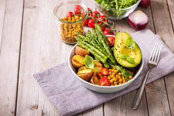 Healthy dinner with green asparagus, lentils and spicy chickpeas, avocado, arugula, vegan, vegetarian healthy food