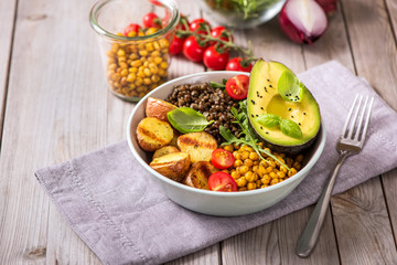 Buddha bowl with baked potatoes, lentils and spicy chickpeas, avocado, arugula, vegan, vegetarian healthy food