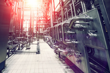 Stainless steel brewing equipment, reservoirs or tanks and pipes and pipelines in modern beer factory. Brewery production concept, abstract industrial background