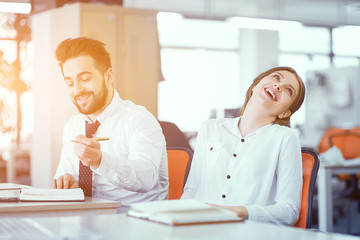 A couple of colleagues at desk in sunny office