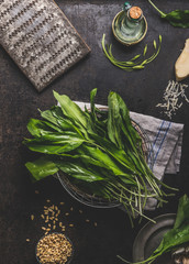 Ramson, wild garlic, leaves bunch on dark rustic kitchen table background with ingredients, top...