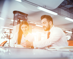 A couple of colleagues at desk in sunny office