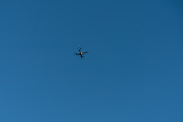 Fototapeta na wymiar Drone flying in the air against the blue sky.technology and radio-controlled machines