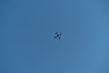 Drone flying in the air against the blue sky.technology and radio-controlled machines