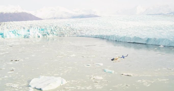 Wide aerial, helicopter flies over glacier in Alaska