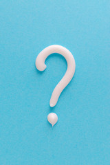 question mark from white toothpaste on blue background