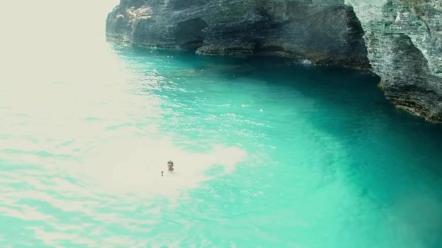Lockdown: Man Relaxing in the Water Beside Cliff in Hamilton Bermuda in Hamilton, Bermuda