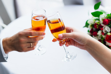 wineglasses of champagne in hands of newlyweds. ring on the ring