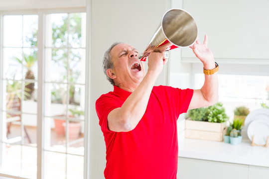 Senior man shouthing excited through vintage metal megaphone