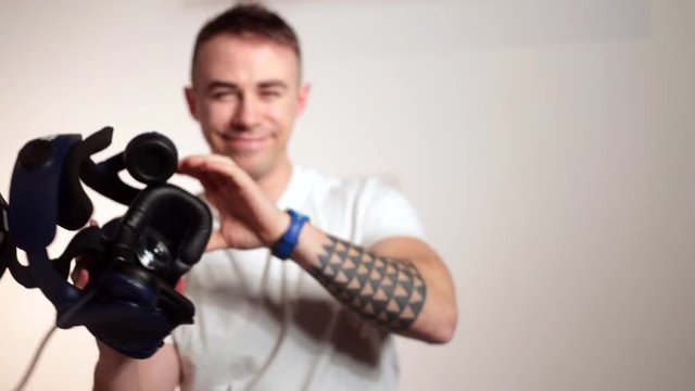 man puts 3d glasses on camera, smiling. Invitation to the world of virtual