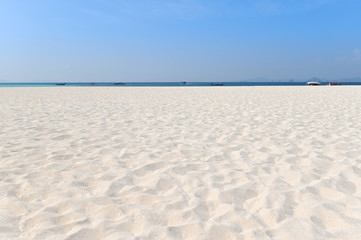 Fototapeta na wymiar Sand on the beach and blue sky as background