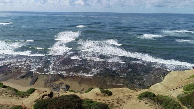 Aerial 4k commercial drone footage overlooking Sunset cliffs, rocks, sand, beach, and ocean waves at sunset cliffs, Point Loma, San Diego, California, USA