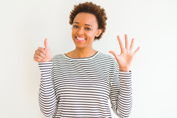 Young beautiful african american woman wearing stripes sweater over white background showing and pointing up with fingers number six while smiling confident and happy.