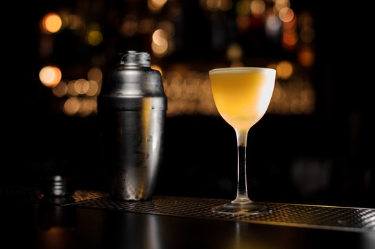 Close-up of an alocohol cocktail and shaker on the bar counter