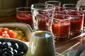 Blueberries in a bowl and smoothies at a breakfast buffet.