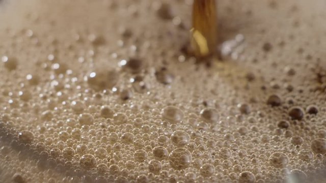 Macro close-up of pouring Cola fizzing and bubbling to the top