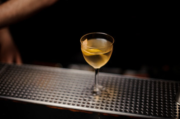 Close-up of alcohol cocktail with lemon rind on counter