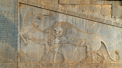 Relief on a temple wall. A lion is attacking a horse. Persepolis, an ancient ceremonial capital of Persian Empire, in modern Iran