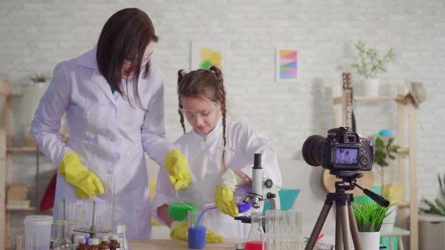 woman and teenage girl blogger,mix the reagents in a chemical laboratory