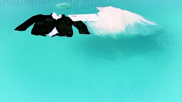 bride and groom's clothes are on the water with just married sign