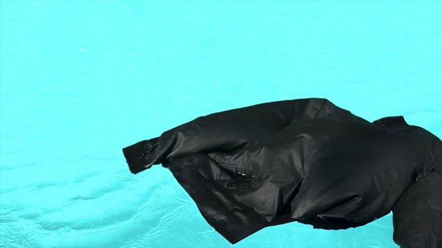 A jacket is swiming in the pool.
