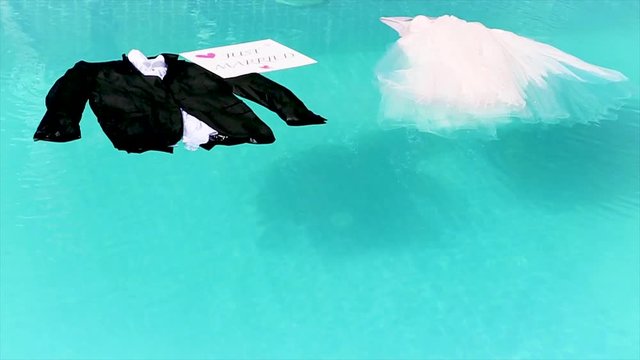 Wedding clothes are in the pool next a sign "Just Married"