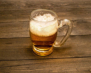 mug with beer on a wooden background
