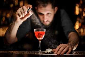 Bartender makes an alcohol cocktail with sprayer