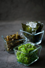 Traditional Japanese Chuka Wakame seaweed salad and crispy roasted nori sheets in glass bowl on dark background top view with copy space.Asian japanese chuka.Organic natural product.Raw vegan food © daarnautova