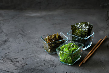 Traditional Japanese Chuka Wakame seaweed salad and crispy roasted nori sheets in glass bowl on...