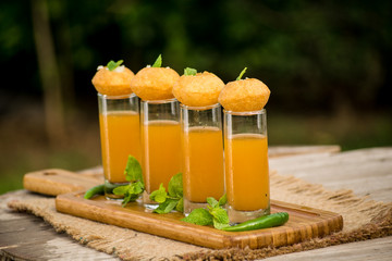 Pani Puri Shots : (a.k.a. golgappa shots or gol gappe shots) are a versatile snack invented in India made of stuffed pani puri (golgappa) placed on top of liquid-filled shot glasses. © Nitin