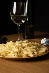 Bodegon of macaroni dish with bolognese sauce and grated cheese and a glass of accompanying wine.