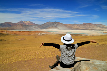 Woman Opening Arms In Front of Awesome View of Salar de Talar salt Lakes and Cerro Medano Mountain,...