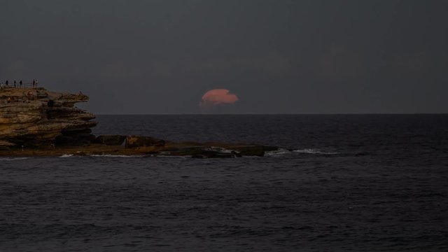 The Full Moon Rising at Bondi Beach. People viewing the moonrise from Ben Buckler.