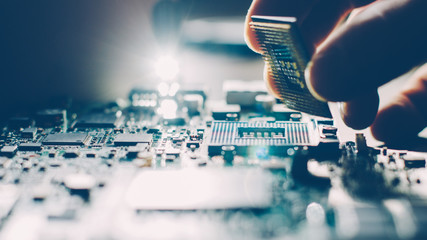 Fototapeta Engineer plugging CPU microprocessor to motherboard socket. Computer technology and hardware maintenance or repair. obraz