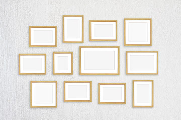 Frames collage, twelve golden realistic frameworks isolated on white plastered wall, interior decor mock up