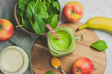 Green smoothie vegan detox with fresh spinach leaves, banana, apples and almond milk. Top view 