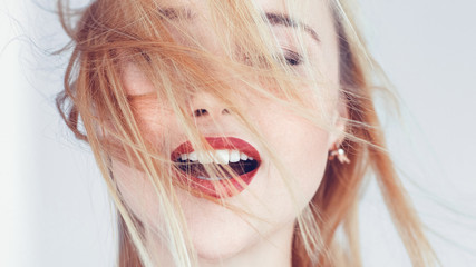 Young blonde woman portrait. Hair blowing in wind. Eyes closed mouth open. Freedom solitude...