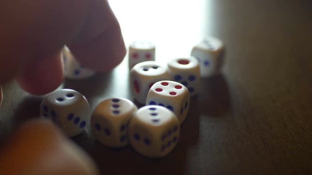 Finger tapping on table with dice on
